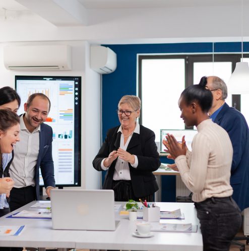 Management team clapping overjoyed in conference room